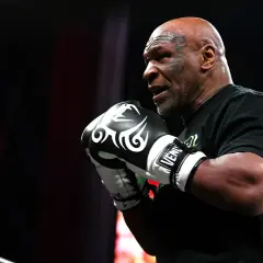 Mike Tyson, a symbol of raw power, shows his enduring strength in boxing gloves.