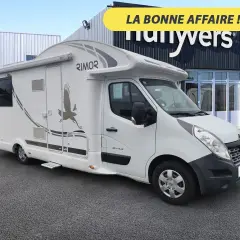 Un camping-car Rimor Katamarano 109 Plus blanc, avec un aigle stylisé sur le flanc, prêt pour l'aventure.