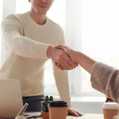 Händeschütteln im Büro: Ein Mann und eine Frau besiegeln eine neue berufliche Orientierung mit 40.