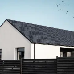 Nowoczesny dom z dachem pokrytym ciemną blachą trapezową na wymiar.