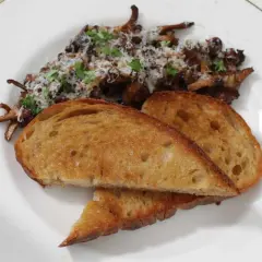 Stekta kantareller med vitlök och persilja, serverade med rostat surdegsbröd. Ett enkelt och gott kantareller recept.
