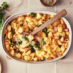 Enkel lyxig middag: krämig pasta med spenat och skinka i ugnsform, redo att serveras.