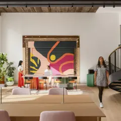 Vibrant mural and spiral staircase showcase current design trends in this modern workspace.