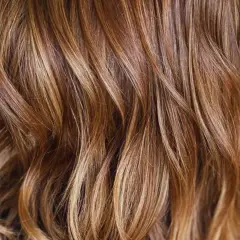Ondas suaves y brillantes con reflejos en pelo castaño, como si el sol jugara entre los mechones.