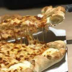 Une part de pizza romaine dégoulinante de fromage fondant est soulevée. Un délice à partager, comme à Rome.