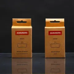 Cajas de SRAM mostrando distintos tipos de pastillas de freno: orgánicas (gris, aluminio, negra) y sinterizadas de cobre.