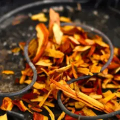 Zrębki do wędzenia w metalowym naczyniu, gotowe do nadania potrawom aromatu.