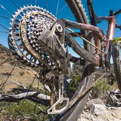 Close-up of a mountain bike's rear derailleur, showcasing its intricate design and the chain. This advanced electronic shifting system ensures smooth gear changes on challenging terrain.