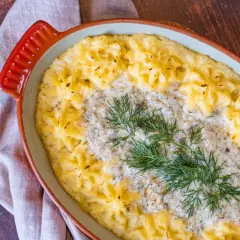 En krämig vegetarisk fisksås med potatismos och dill i en ugnsform.