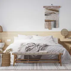 Dormitorio acogedor con lámparas de techo sin punto de luz, cama con mantas grises y tapiz de pared.