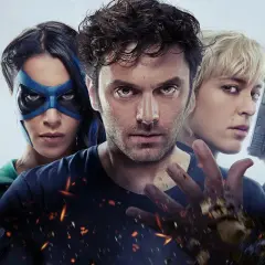 Trois personnages d'un film de super-héros : une femme au masque bleu, un homme au regard intense et une femme blonde tenant un pistolet.