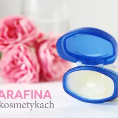 Otwarty słoiczek z wazeliną, która zawiera parafinum liquidum, na tle różowych róż.