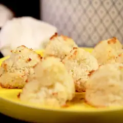 En gul tallrik med nybakade kokostoppar. Perfekt för dig som söker ett enkelt kokostoppar recept.