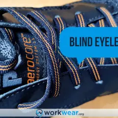 Close-up of a dark blue Timberland boot with orange stitching. The laces go through what are called blind eyelets, a feature that keeps them secure.