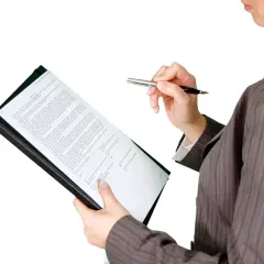 Kobieta w garniturze analizuje dokumenty, przygotowując się do kontroli nadzoru budowlanego.