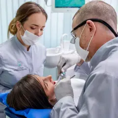 Dentysta leczy zęby pacjentki. Czy próchnica jest zaraźliwa? Warto zapytać specjalistę.