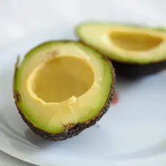 Dwa połówki awokado na talerzu, idealne do guacamole.
