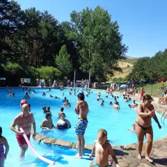 Gente disfrutando de un día soleado en la piscina de la panera Segovia.