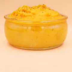 Pyszne, kremowe puree z batata w szklanym naczyniu, posypane świeżo mielonym pieprzem. Idealne jako dodatek do obiadu.