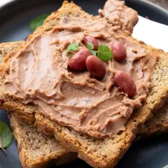 Pyszna pasta z fasoli czerwonej na chrupiących grzankach, ozdobiona fasolkami i listkami ziół. Idealna na szybką przekąskę.
