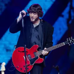 James Arthur śpiewa i gra na czerwonej gitarze na koncercie w Warszawie.