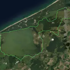 Zielona trasa rowerowa okrążająca jezioro Gardno, prowadząca przez lasy i pola, zaczyna się w Rowach.