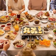 Une joyeuse tablée partage une raclette maison conviviale, avec fromage fondant, charcuteries et légumes variés.