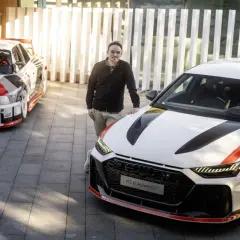 Mężczyzna stoi obok nowoczesnego Audi RS6 Avant GT, a w tle historyczny Audi Quattro.