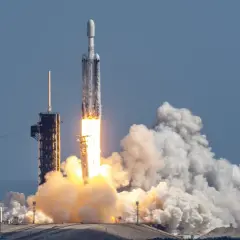 Rakieta Falcon Heavy SpaceX startuje, wzbijając się w niebo z potężnym płomieniem i kłębami dymu.