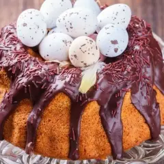 Babka gotowana przepis: puszysta babka z polewą czekoladową, posypką i ozdobiona wielkanocnymi jajeczkami.