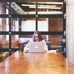Kobieta pracuje przy laptopie, tworząc MVP. To skrót od Minimum Viable Product, czyli najprostszej wersji produktu.