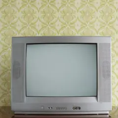 Stary kineskop na tle tapety w zielone wzory. Czekał na ulubiony program.