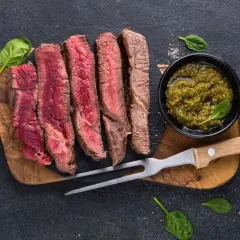 Perfekt gegrilltes Steak, in Scheiben geschnitten, mit Kräutersauce und frischem Spinat. Ein Genuss für jeden Fleischliebhaber.