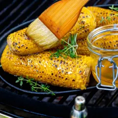 Grilla majskolv på grillen, pensla med smält smör och garnera med färska örter. En härlig sommardessert!