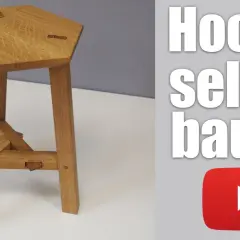 Ein sechseckiger Holzhocker mit drei Beinen, der zeigt, wie man einen dreibein holz selber bauen kann.