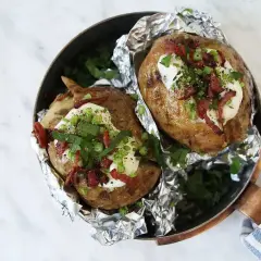 Två bakade potatisar med krämig fyllning, knaprigt bacon och färska örter. En härlig bakad potatis fyllning som ser utsökt ut.
