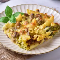 Pyszny makaron z mięsem mielonym w sosie śmietanowo-serowym, zapieczony z brokułami i posypany serem.