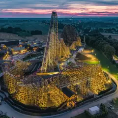 Drewniany gigant, największy rollercoaster w Europie, lśni w blasku nocnych świateł. Jego imponująca konstrukcja wznosi się ku niebu, zapraszając na niezapomnianą przygodę.