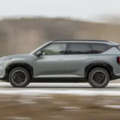Szary Kia EV5 w ruchu, z rozmytym tłem sugerującym prędkość.