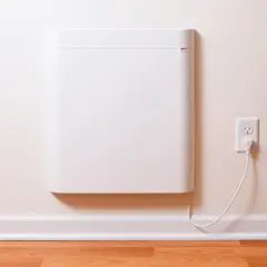 Un radiateur électrique blanc, moderne et discret, est branché à une prise murale. Ce type de radiateur est une solution de chauffage efficace.