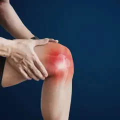 Uomo che si tiene il ginocchio, evidenziato in rosso, indicando dolore sopra ginocchio interno.