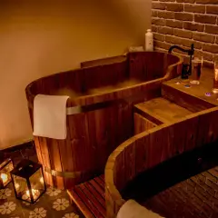 Drewniane wanny SPA z parą, świecami i napojami.