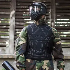 Gracz w kamizelce ochronnej i masce, gotowy do gry. Tak się ubiera na paintball, by czuć się bezpiecznie i komfortowo.