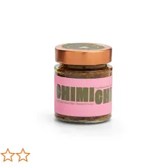 Frasco de vidrio con salsa chimichurri tradicional, etiqueta rosa con letras verdes y tapa dorada.