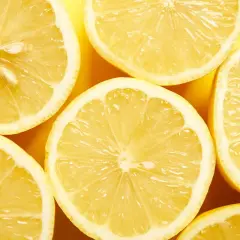 Plasterki soczystej cytryny na żółtym tle. Wyobraź sobie, że to naturalny sposób na piękny połysk paznokci.