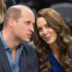 Księżna Kate w czwartej ciąży, uśmiechnięta, rozmawia z księciem Williamem.