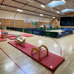 Gerätelandschaft im TSG Bewegungszentrum: bunte Matten, Wippe, Kletterbogen und mehr laden zum Toben ein.