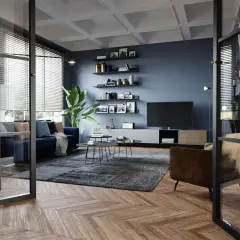 Soggiorno moderno con divano blu, poltrona marrone, tappeto grigio e TV. Idee su come arredare un soggiorno con stile e funzionalità.