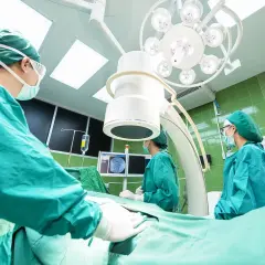 Chirurghi in sala operatoria, concentrati sul loro lavoro. La loro **responsabilità professionale** è evidente in ogni gesto.