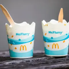 Dwa kubki McFlurry z McDonald's z drewnianymi łyżeczkami.
